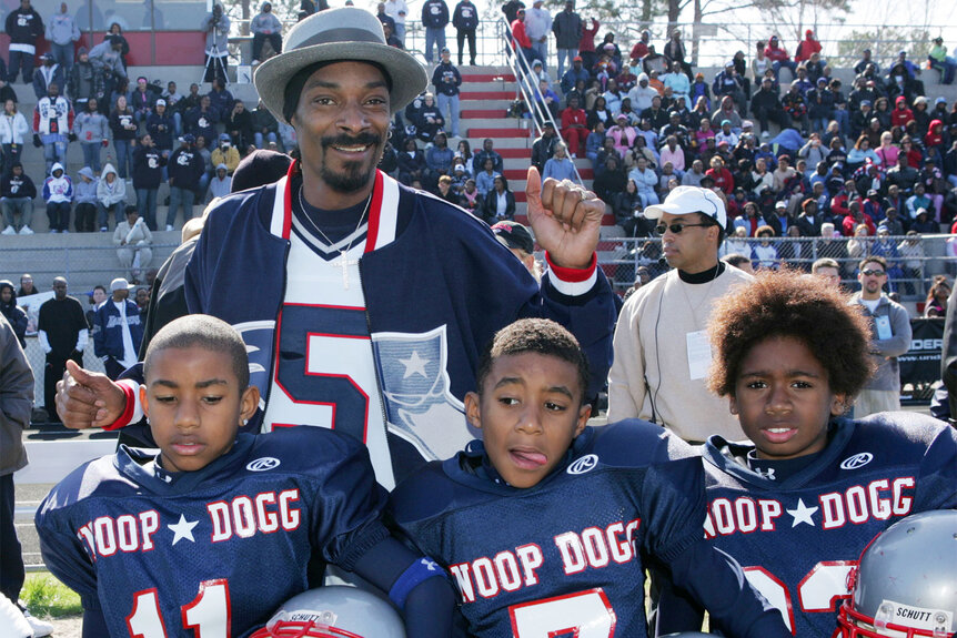 Snoop Dogg poses with players during the